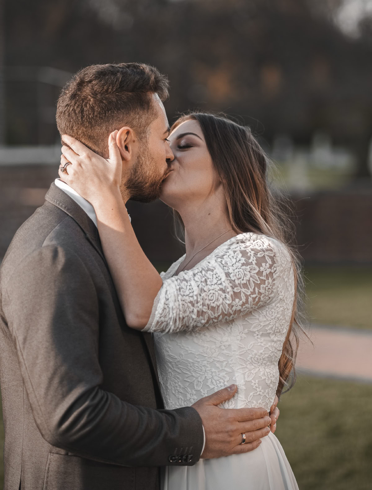 Ein Paar in eleganter Kleidung küsst sich im Freien.